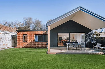 blackburn Contemporary home extension with gable roof, black and brick exterior finishes, and spacious outdoor entertaining area, designed by Coy's Constructions in Australia.